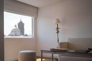 A room with a view of a historic building, a lamp, a sofa, and a table. - Palacio San Leonardo (Puebla)