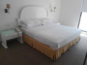 A hotel room with a single bed, a nightstand, a lamp, and a window. - Palacio San Leonardo (Puebla)
