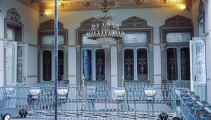 A room with ornate ceiling details, a chandelier, and a patterned floor. - Palacio San Leonardo (Puebla)