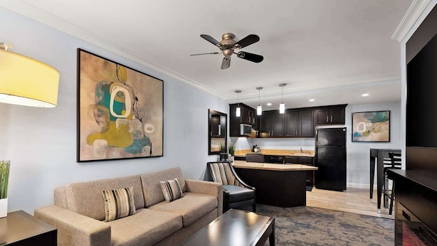 A modern living room with a sofa, coffee table, and artwork on the wall. - Manhattan Beach Hotel (Manhattan Beach)