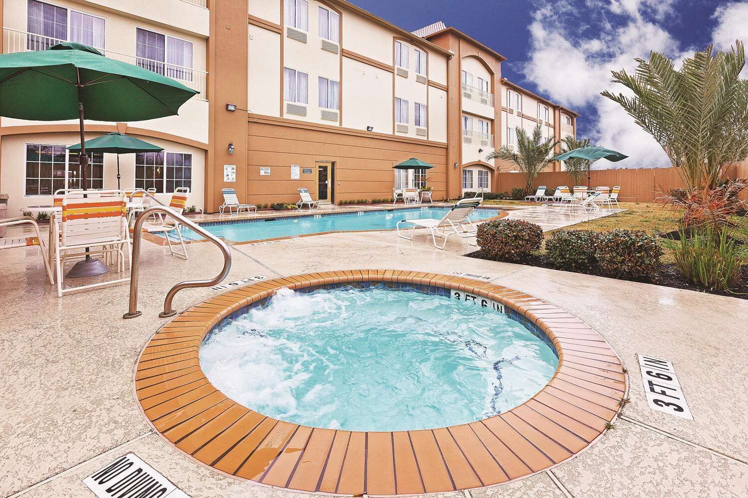 Um hotel com área de piscina, incluindo uma banheira de hidromassagem e espreguiçadeiras.