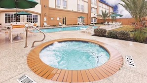 A hotel with a pool area, including a hot tub and lounge chairs. - Houston Hobby Airport (Houston)