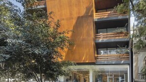 A modern building with multiple balconies, large windows, and a prominent vertical wooden panel. - Amberes 64, an Ascend Collection Hotel (Mexico City)