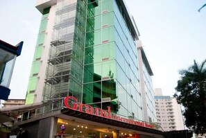 Un hotel con fachada de vidrio moderna y un cartel rojo llamativo.