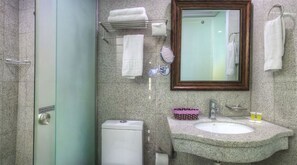 Ein Badezimmer mit Waschbecken, Spiegel, Handtuchhalter und Toilette.