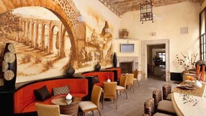 A spacious lounge with a mural, comfortable seating, and a fireplace.
