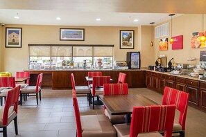 Un restaurant avec des chaises à revêtement rouge, un comptoir de buffet et une variété de plats exposés.