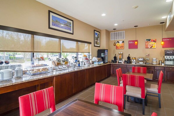 A breakfast bar with seating, a coffee station, and a view of the outdoors. - Red Roof Plus+ San Antonio Northeast (San Antonio)