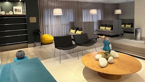 Una sala de estar moderna con un conjunto de sofá, una mesa redonda de centro y una pelota de ejercicios amarilla.