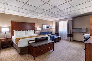 A hotel room with a large bed, a sofa, a desk, and a TV. - Comfort Inn Butte City Center I-15 / I-90 (Butte)