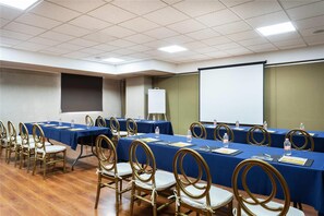 A conference room with multiple tables, chairs, and a projector screen. - Comfort Inn Puebla Centro Historico (Puebla)
