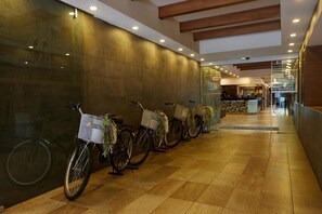 Uma fileira de bicicletas com cestas, um balcão de atendimento e um chão de azulejos.