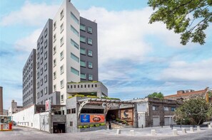 A modern hotel with a prominent entrance, a visible restaurant sign, and a clear sky. - Comfort Inn Puebla Centro Historico (Puebla)