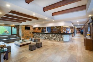 A hotel lobby with a reception desk, seating area, and a view of the outdoors. - Comfort Inn Puebla Centro Historico (Puebla)