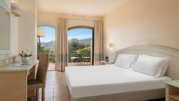 Una camera d'albergo con un letto, una scrivania, una sedia e vista sull'esterno.
