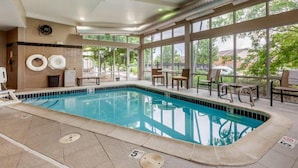 A swimming pool with a tiled edge, a sunroof, and a view of the outdoors. - Cambria Hotel Ft Collins (Fort Collins)