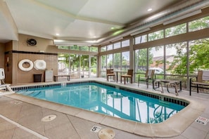 A swimming pool with a tiled edge, a sunroof, and a view of the outdoors. - Cambria Hotel Ft Collins (Fort Collins)
