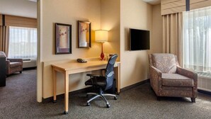 A hotel room with a desk, chair, TV, and large window. - Cambria Hotel Ft Collins (Fort Collins)