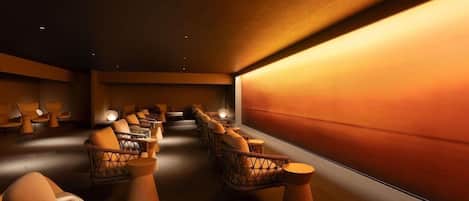 A spa room with multiple seating areas, including cushioned chairs and a sofa, arranged in a row.