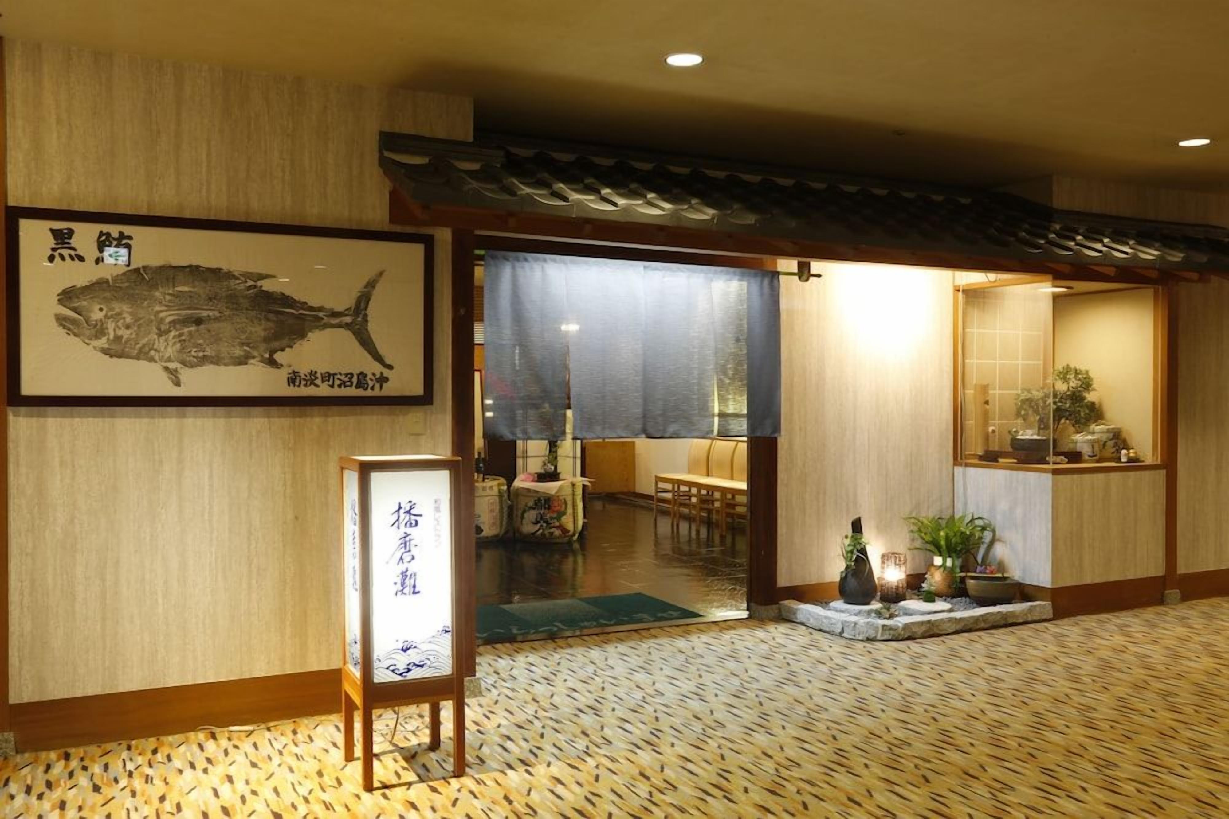 Un restaurante japonés tradicional con suelo de tatami, una ilustración enmarcada de un pez y un cartel.