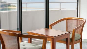 Habitación con vistas a un puente y al agua, una mesa de madera y dos sillas.