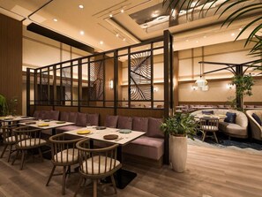 Un restaurante con mobiliario de madera, techo alto y paneles decorativos en las paredes.