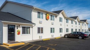 A motel with a 'Super 8' sign, a parking lot, and a black car parked in front. - Super 8 Sheridan (Sheridan)