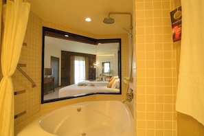 A bathroom with a large mirror, a bathtub, and a shower.