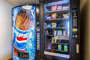 Un distributeur automatique orné du logo Pepsi et proposant un assortiment de collations.