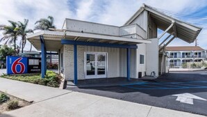 A motel with a single-story structure, a covered entrance, and a parking lot.