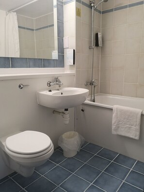 A bathroom with a toilet, sink, and bathtub.