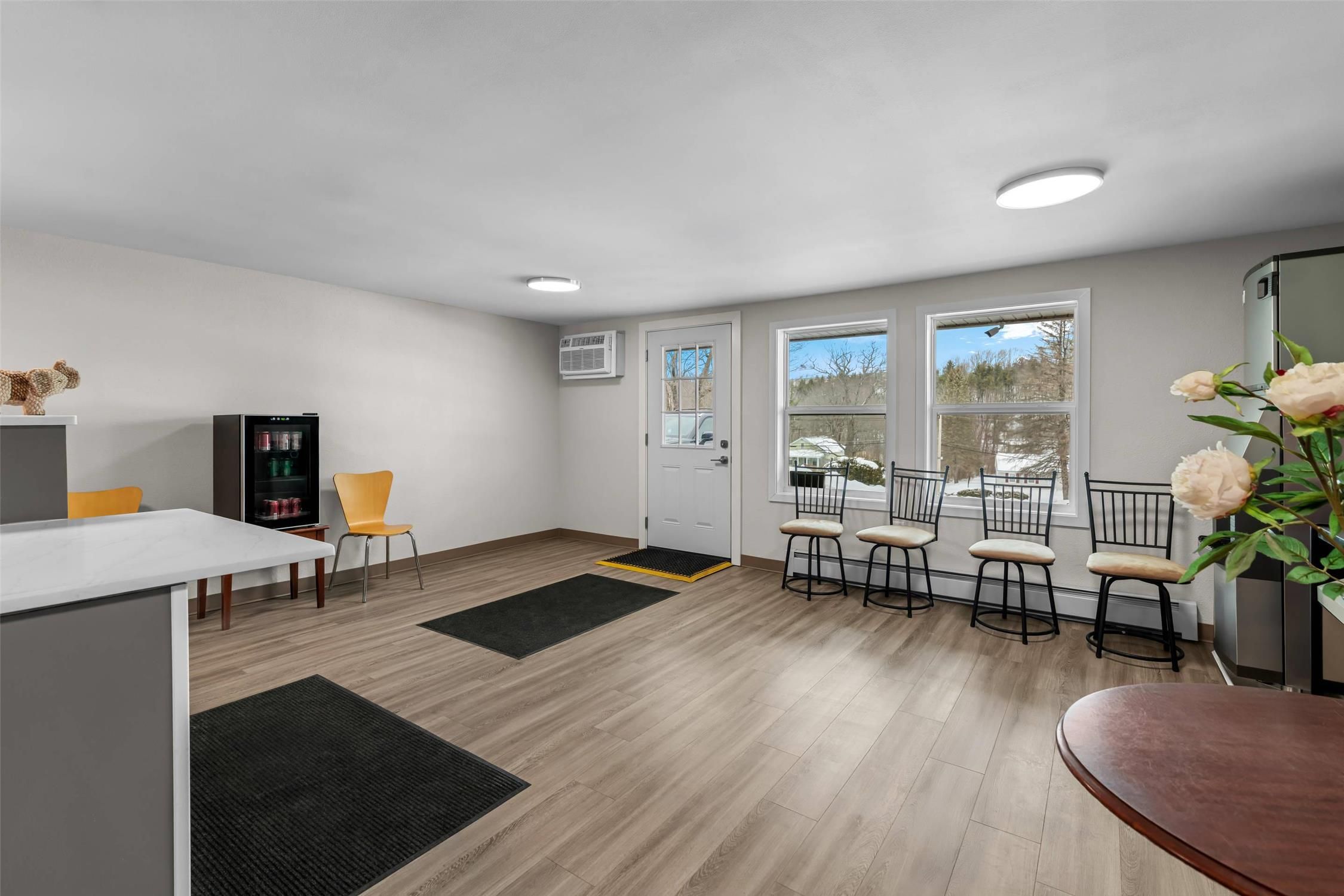 A modern kitchen with a dining area, a refrigerator, and a coffee machine.