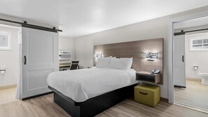 Un dormitorio moderno con cama, mesita de noche y espejo.