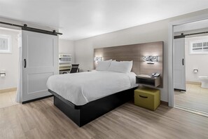 Un dormitorio moderno con cama, mesita de noche y espejo.