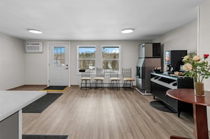 Una cocina compacta con comedor, refrigerador y cafetera.