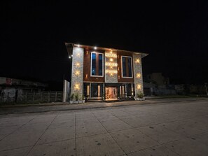 Un hotel moderno con una estructura de dos pisos, ventanas amplias y una entrada bien iluminada.