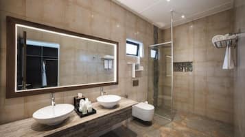 A modern bathroom with two sinks, a large mirror, and a glass shower enclosure.