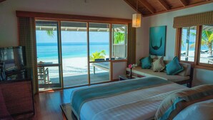 Un dormitorio con una cama grande, televisión y vista a la playa.