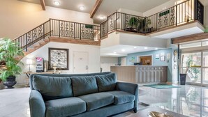 A spacious living area with a large sofa, a coffee table, and a staircase leading to an upper level.
