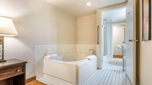 A modern bathroom with a bathtub, a toilet, and a shower area.