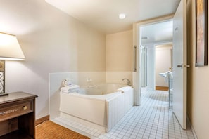 A modern bathroom with a bathtub, a toilet, and a shower area.
