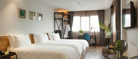 Una habitación de hotel con cama, escritorio, silla, televisor y planta.