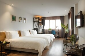 A hotel room with a large bed, a desk, a chair, a TV, and a plant. - C Central Hotel de Tham (Ho Chi Minh City)