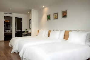 A hotel room with two beds, a wooden headboard, a dining area, and a kitchenette. - C Central Hotel DE Tham (Ho Chi Minh City)