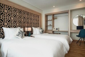 A hotel room with two beds, a wooden decorative wall, a built-in shelf, a desk, and a chair. - C Central Hotel de Tham (Ho Chi Minh City)