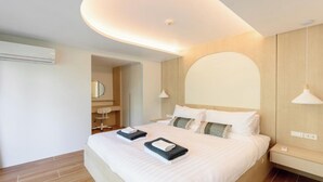 Ein modernes Hotelzimmer mit einem großen Bett, Nachttischen, einem Spiegel und einer Deckenleuchte.