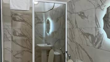 Chuveiro, toalhas de banho, papel higiênico