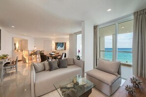 Ein modernes Wohnzimmer mit Sofa, Couchtisch und Essbereich.