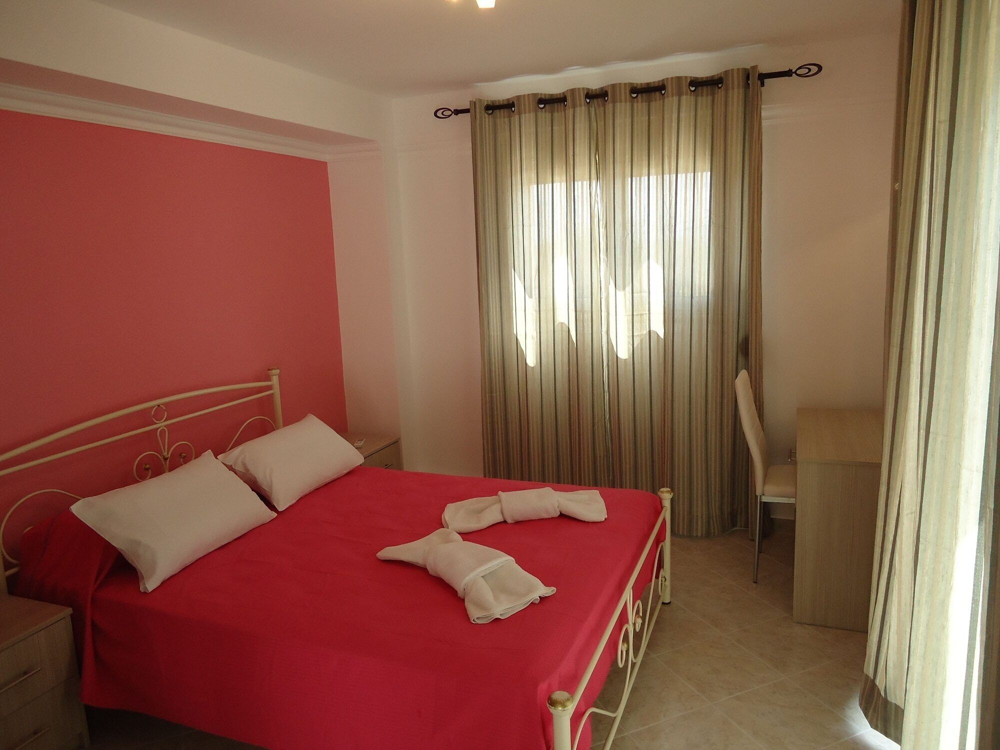 A hotel room with a bed, a desk, and a chair.