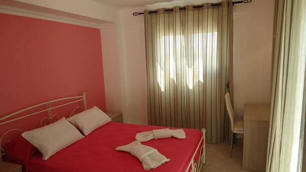 Une chambre d’hôtel avec un lit, un bureau et une chaise.
